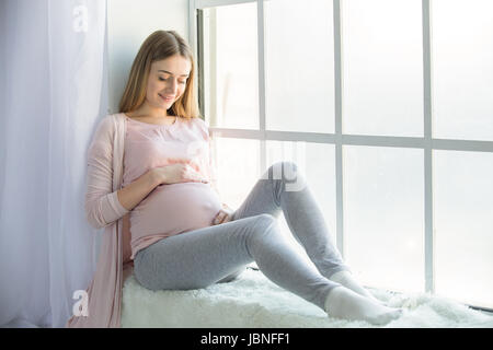 Jeune femme preganant attend un petit parent heureux Banque D'Images