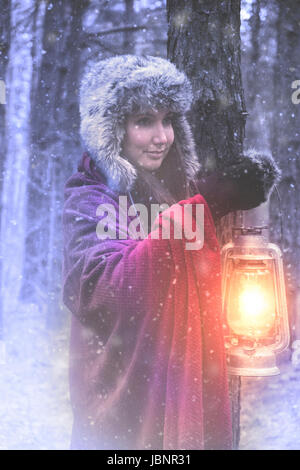 Femme avec lanterne en forêt d'hiver Banque D'Images