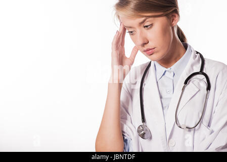 Femme médecin / Infirmière avec migraine surchargés et stressés. Professionnel de la santé in lab coat wearing stethoscope à l'hôpital. Banque D'Images