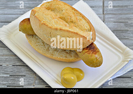 Rouleau de saucisse grillée sur du papier blanc plaque avec la moutarde, Close up, macro, full frame, fond gris Banque D'Images