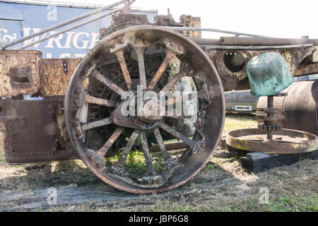 Grande roue arrière en fer rouillé d'une épave 1926 John Fowler 10 tonne à vapeur dans un cimetière de véhicules. Banque D'Images