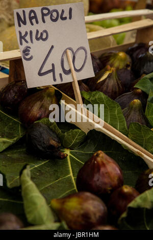 Fichi- mûres, figues italien sucré sont nichés au milieu d'un vert profond, les feuilles de vigne. Mis en caisses, ils font une belle affiche au marché de Venise. Banque D'Images