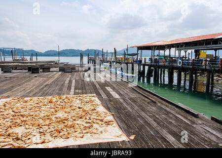 Une jetée et de poissons séchant au soleil sur l'île de Pangkor (Pulau Pangkor, Malaisie). Banque D'Images