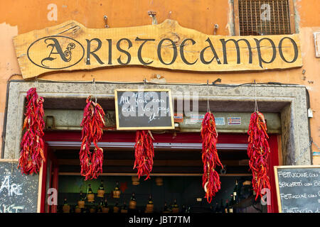 Restaurant dans une allée de Trestastevere, quartier typique de rome. Panneau du restaurant et piments rouges suspendus. Rome, Italie, Europe, UE. Banque D'Images