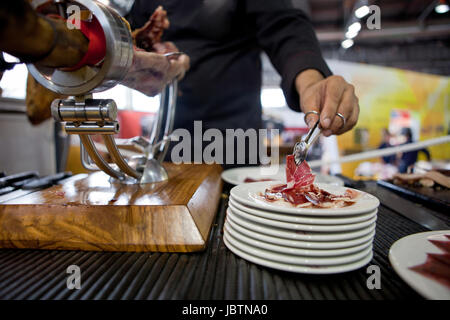 Waiter serving acorn-jambon ibérique nourris, Espagne Banque D'Images