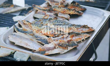 Le chef travaille sur un grill, poisson de friture rapans et de calmars. Filet de maquereau de cuisson grill à poisson pour le blé dur. Au rez-de-grillein avec poisson barbecue Banque D'Images