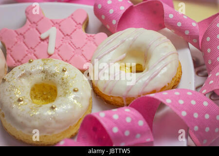 Premier anniversaire - cookies glaçage royal forme couronne cookie et décoré des beignes Banque D'Images