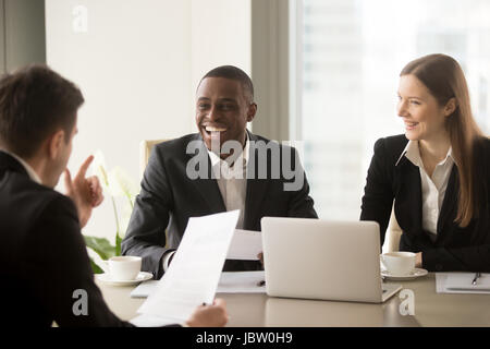 African American businessman avec beau sourire rayonnant sur rire international multi-ethnique quand la réunion de l'équipe disant partenaire blague, cheerful divers Banque D'Images