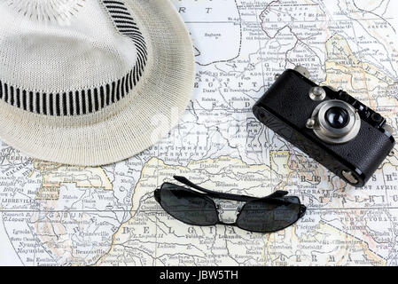 Photographie d'une carte ancienne avec un appareil photo vintage, lunettes de soleil et chapeau blanc Banque D'Images