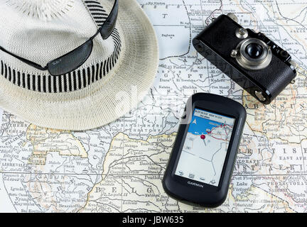 Photographie d'une carte ancienne avec un appareil photo vintage, unité GPS, lunettes de soleil et chapeau blanc, concept de voyage, accessoires technologiques Banque D'Images