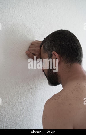 L'homme eatsern milieu déprimé appuyé contre le mur Banque D'Images