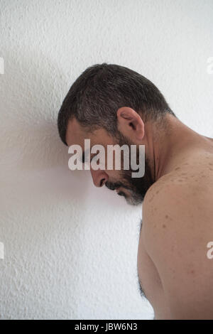 L'homme eatsern milieu déprimé appuyé contre le mur Banque D'Images