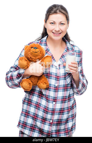 Belle fille chaude en pyjama avec un bien-aimé porter et le lait sur un fond blanc Banque D'Images