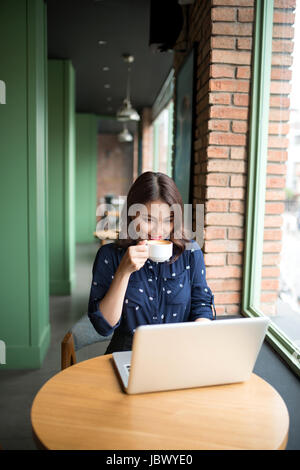 Belle jeune femme asiatique mignon dans le café, profiter de boire du café smiling Banque D'Images