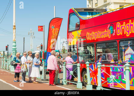 Bus de tourisme. Personnes âgées touristes à bord de l'open top bus de tourisme sur le front road à Brighton. East Sussex, England, UK. Banque D'Images