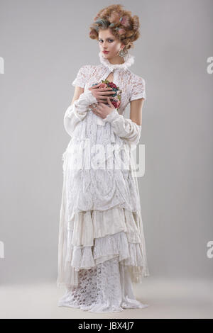 L'élégance. Superbe mannequin en longue robe et Bouquet de fleurs Banque D'Images