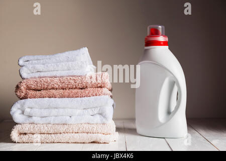 Pile de plusieurs couleurs et les serviettes blanches et une bouteille de produit cosmétique. Banque D'Images