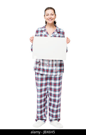 Brunette de 30 ans en pyjama en pleine longueur avec une affiche vide sur un fond blanc Banque D'Images