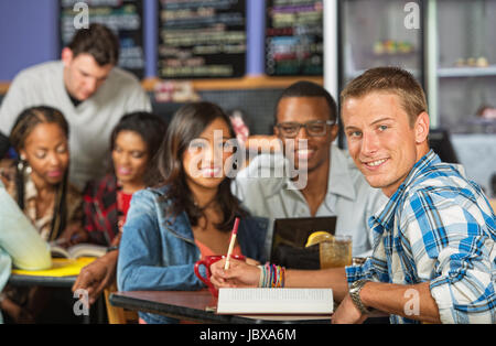 Beau Caucasian student faire leurs devoirs avec des amis Banque D'Images