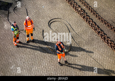 Les dockers du navire amarré hawser à shoreside bitt à quai du port Banque D'Images