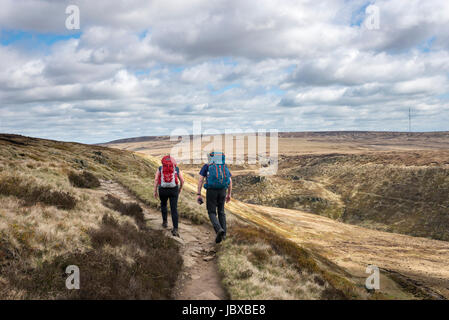Un couple en train de marcher sur des rochers près de Laddow Crowden sur le Pennine Way, North Derbyshire, Angleterre. Banque D'Images