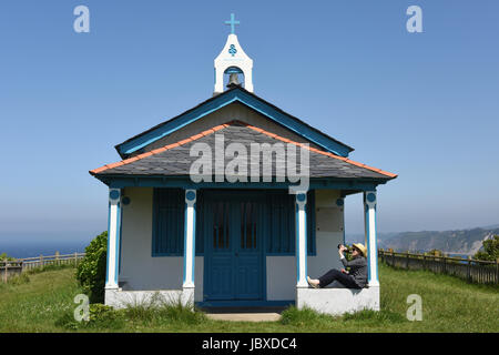 Femme buvant bouteille de bière à la chapelle de la Regalina, Cadavedo, Asturias, Espagne Banque D'Images