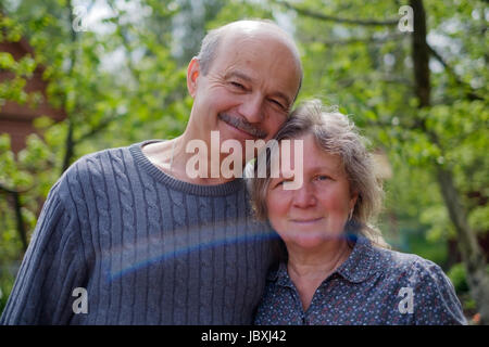 Smiling Mature Couple en arrière cour jardin en journée ensoleillée. Ils sourient et regarder camera Banque D'Images