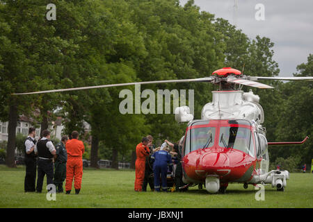 Un hélicoptère AgustaWestland AW139 exploité par le Royaume-Uni de sauvetage de la Garde côtière a brriefly a atterri à Ruskin Park pour offrir un traitement d'urgence, le 8 juin 2017, dans le sud London Borough of Lambeth, Angleterre. L'AW139 est utilisé par les garde-côtes de Sa Majesté (HMCG) qui est une section de la Maritime and Coastguard Agency responsable de l'initiation et la coordination de toutes les activités de recherche et sauvetage (SAR) au sein de l'UK maritimes de recherche et de sauvetage. Banque D'Images