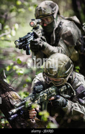 Groupe de soldats des forces spéciales au cours de la forêt en raid Banque D'Images