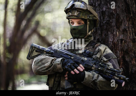 Portrait de soldat avec mitraillette debout dans les bois pendant la journée Banque D'Images