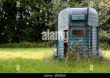 Weathered horsebox debout dans la lumière du soleil dans une prairie d'herbes hautes dans la New Forest, en Angleterre Banque D'Images