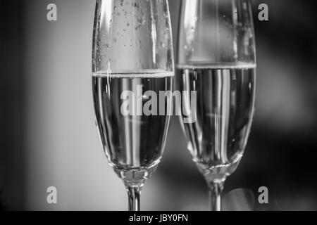 Image noir et blanc macro de bulles de champagne dans deux verres Banque D'Images