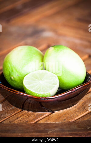 Fresh citrus limetta wholes et coupe sur table en bois Banque D'Images