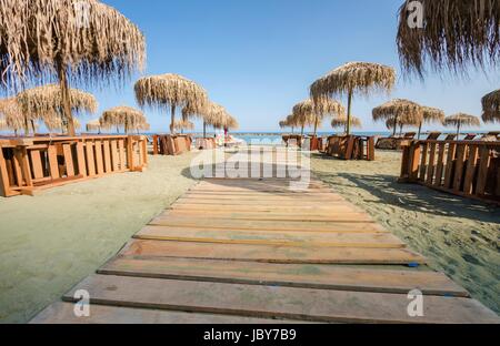 Une vue d'été de la plage de Limassol à Chypre dans Neapoli, près de l'Olympic Residence. Une vue sur le sable, la mer Méditerranée, tropical et exotique de parasols et chaises longues et la promenade de chemin d'accès à la mer Banque D'Images