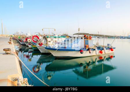 Les bateaux de pêche amarrés dans le vieux port de Limassol à Chypre, à côté de la marina de l'autorité des ports. Une vue sur le port, la mer Méditerranée, l'eau, de bateaux et de filets de pêche et du matériel de pêche. Banque D'Images