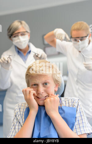 Peur adolescent à une chirurgie dentaire dentiste femme avec assistant Banque D'Images