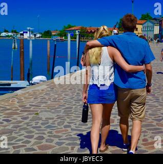 Couple en train de marcher le long de Quay à Murano, Italie Banque D'Images