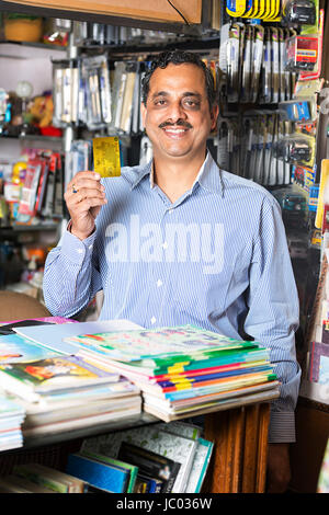 1 Indian shop keeper man showing carte de crédit en magasin stationnaire Banque D'Images