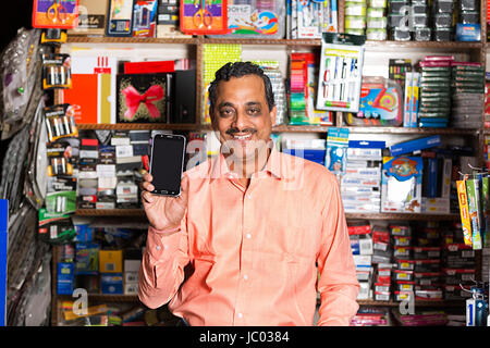 1 Indian shop keeper man nouveau smartphone dans l'arrêt shop Banque D'Images