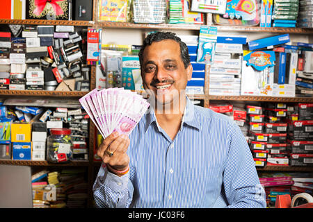 1 Indian shop keeper man showing argent roupies dans l'arrêt shop Banque D'Images