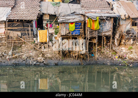 Les habitations et cabanes dans des taudis sont entièrement meublé situé à une rivière sale Banque D'Images