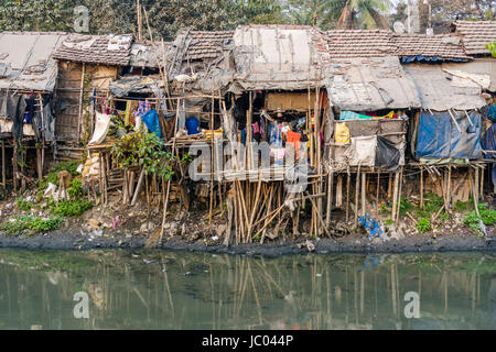 Les habitations et cabanes dans des taudis sont entièrement meublé situé à une rivière sale Banque D'Images