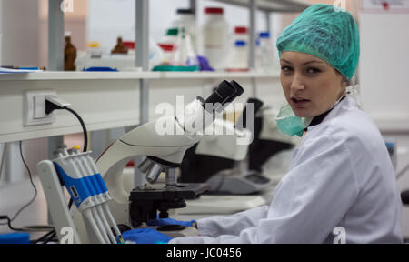 Belle femme chercheur scientifique ou médical ou d'une femme médecin regardant la caméra dans un laboratoire scientifique. Les jeunes de faire des recherches. Banque D'Images