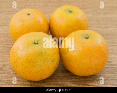 Quatre Oranges Douces et mûres sur une table en bois, l'Orange est le fruit de l'espèces d'agrumes. Banque D'Images