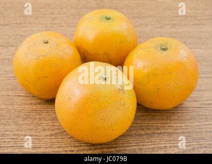 4 Oranges Douces et mûres sur une table en bois, l'Orange est le fruit de l'espèces d'agrumes. Banque D'Images