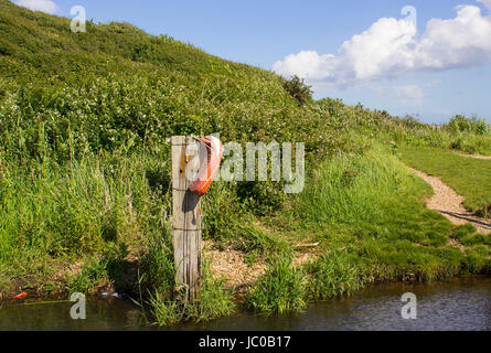 Un sauvetage aide flottabilité négligées lors d'une petite passerelle sur le Solent Way beach sur le chemin de l'eau près de Southampton, Hampshire commun Titchfield. Banque D'Images