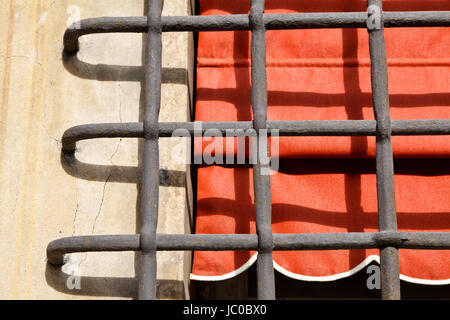 Grille et fenêtre avec rideau rouge à Gênes, Italie Banque D'Images