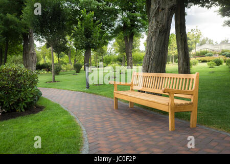 Grand banc en bois sous les arbres au magnifique parc Banque D'Images