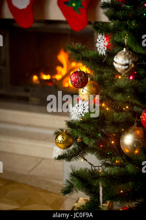 Beau fond d'arbre de Noël décoré en face d'une cheminée à la maison Banque D'Images