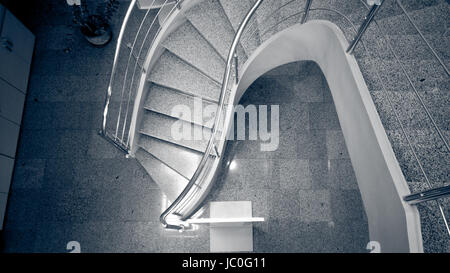 L'image monochrome aux couleurs de l'escalier de pierres incurvées au bâtiment moderne Banque D'Images